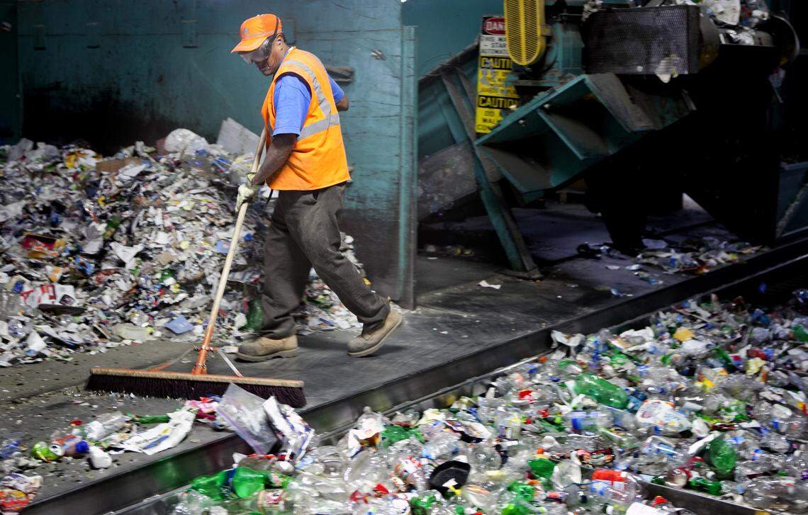 Ernesto Prudeste clears the floor under sorting machinery at Sonoco Recycling Center on Feb. 16, 2012.