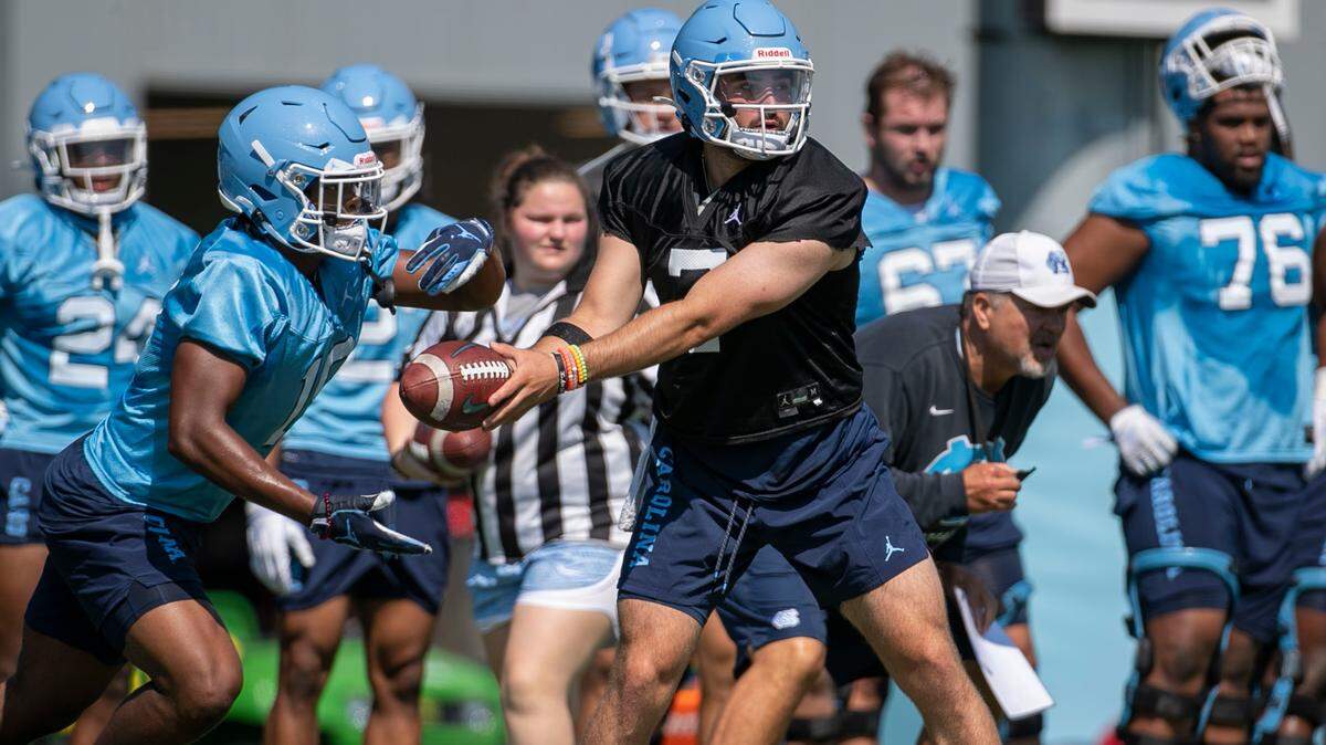 North Carolina running back Ty Chandler (19) takes a hand-off from quarterback Sam Howell (7) during the Tar Heels’ first day of practice on Thursday, August 5, 2021 in Chapel Hill N.C.