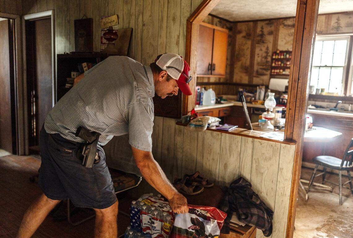 Zach Banks places a bag of dog food inside Marty Dillingham’s home in Barnardsville, N.C. on Wednesday, October 2, 2024.