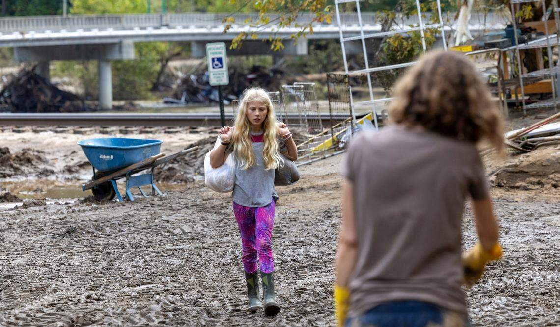 Residents and volunteers clean up on Tuesday, Oct. 1, 2024 after the French Broad River flooded downtown Marshall. The remnants of Hurricane Helene caused widespread flooding, downed trees, and power outages in western North Carolina.