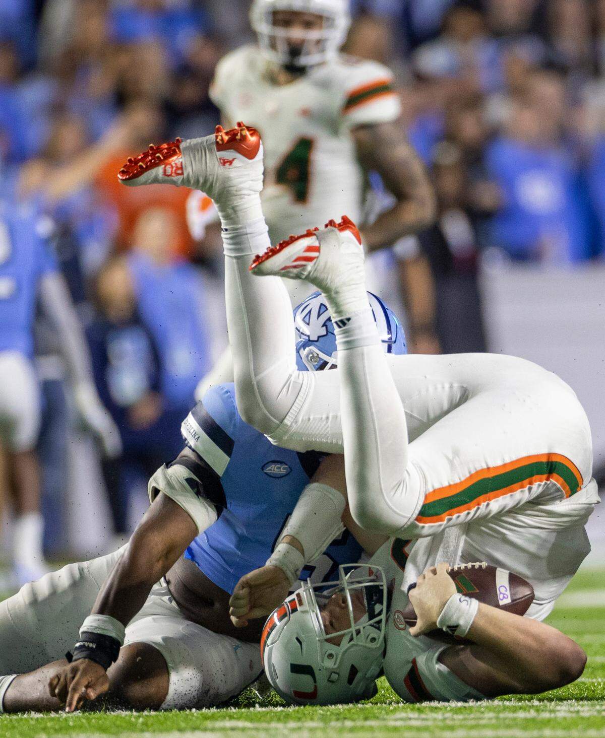 Miami quarterback Tyler Van Dyke (9) is dropped for an 11-yard loss by North Carolina’s Jahvaree Ritzie (5) and Beau Atkinson (12) in the third quarter against Miami on Saturday, October 14, 2023 at Kenan Stadium in Chapel Hill, N.C.
