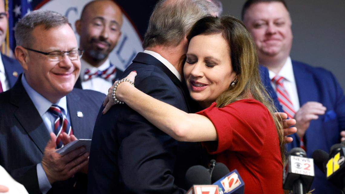 N.C. Rep. Tricia Cotham gets a hug from N.C. Senate leader Phil Berger as House Speaker Tim Moore, left, looks on during a press conference April 5, 2023, to announce that Cotham was switching parties to become a member of the House Republican caucus.