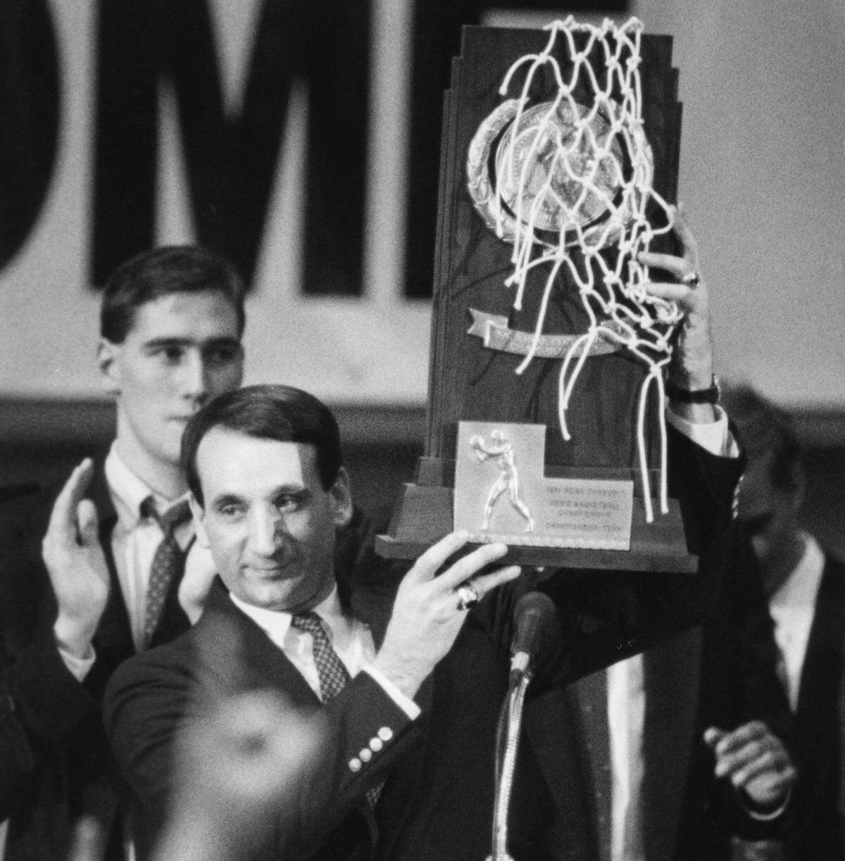 Duke coach Mike Krzyzewski holds up the National Championship trophy to the crowd during a celebration in Cameron Indoor Stadium April 2, 1991.