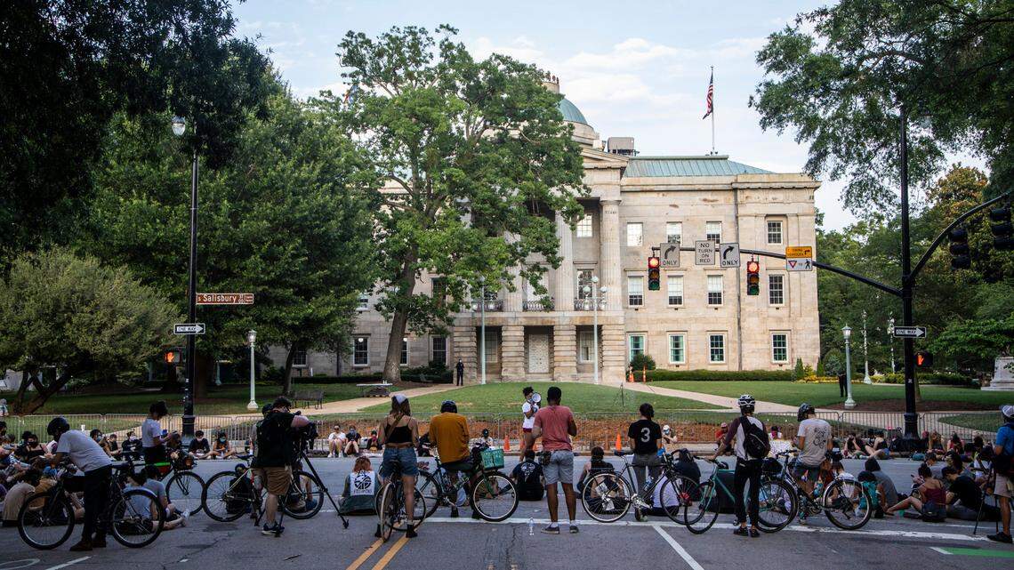 Protesters rally near the former site of the NC Confederate Monument before learning the news that N.C. Gov. Roy Cooper vetoed SB 168, which would have restricted death investigation records, Monday, July 6, 2020.