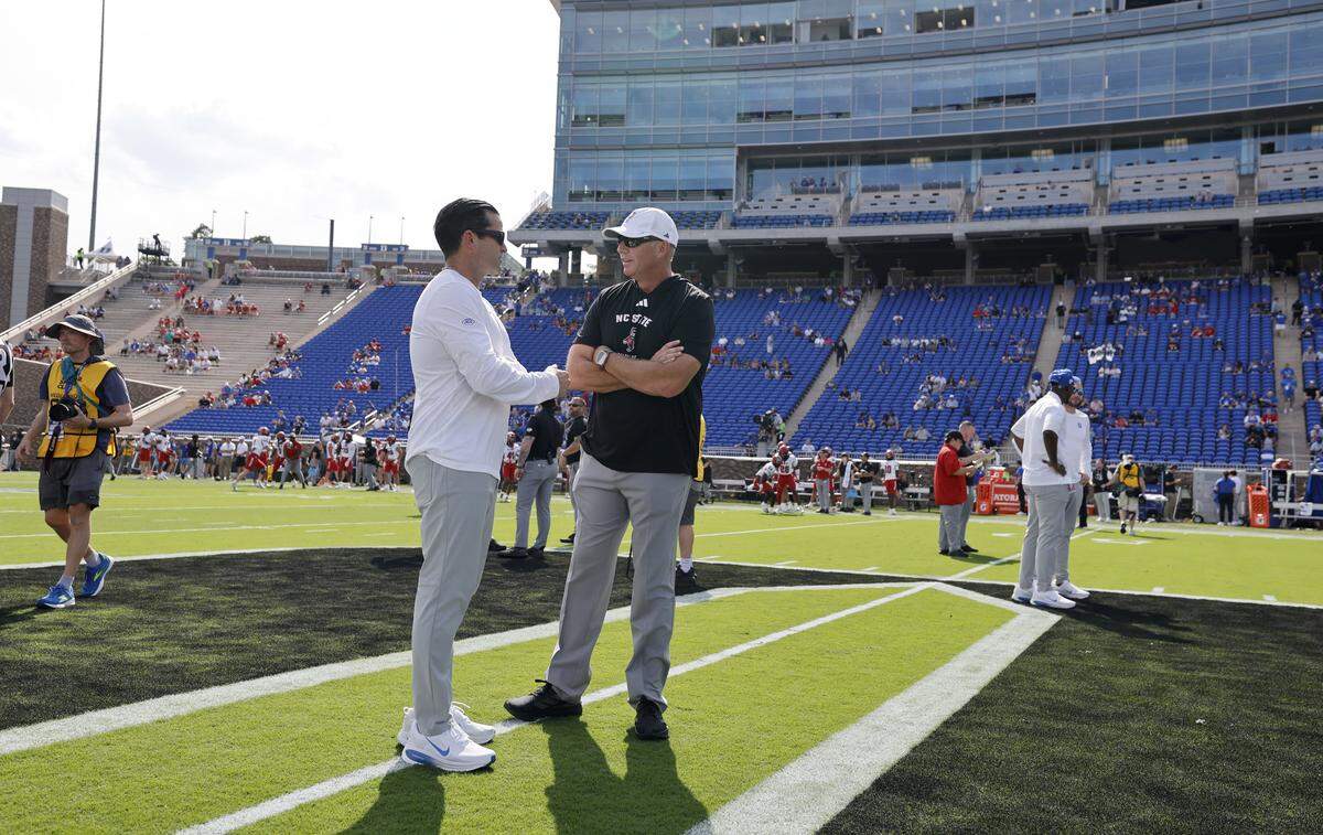 N.C. State head coach Dave Doeren talks with Duke head coach Manny Diaz before N.C. State’s game against Duke at Wallace Wade Stadium in Durham, N.C., Sat. Sept. 20, 2025
