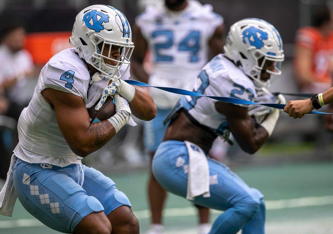 North Carolina running backs Caleb Hood (4) and George Pettaway (23) work on their ball handling skills as they warm up for their game against Miami on Saturday, October 8, 2022 at Hard Rock Stadium in Miami Gardens, Florida.