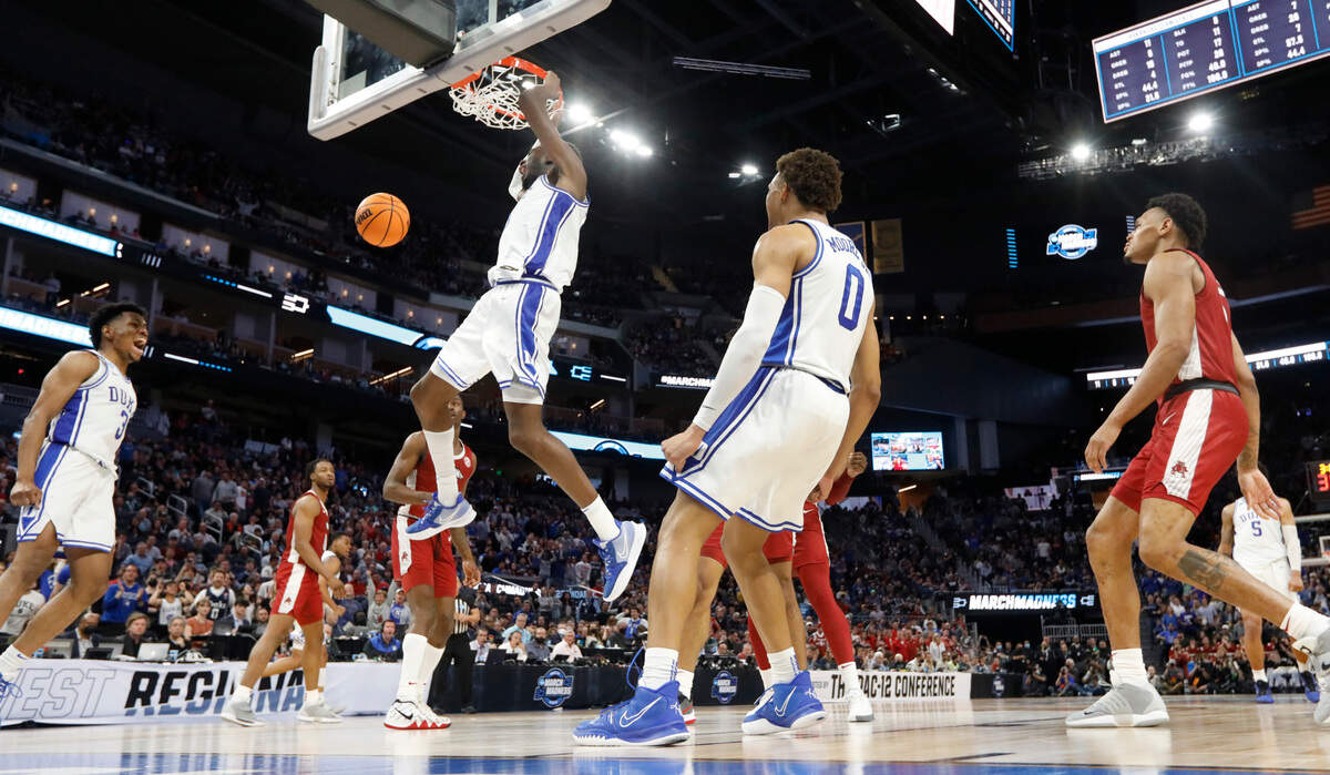 Duke’s Jeremy Roach (3) and Wendell Moore Jr. (0) react as Mark Williams (15) slams in two during Duke’s 78-69 victory over Arkansas in the NCAA Tournament West Regional finals at the Chase Center in San Francisco, Calif., Saturday, March 26, 2022.