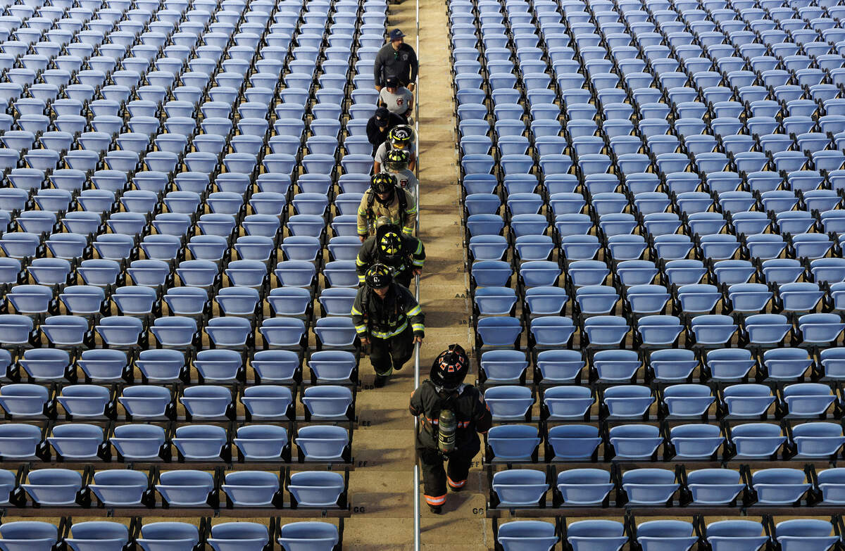 Participants climb the stairs amid a sea of blue seats at Kenan Memorial Stadium during an event in Chapel Hill, N.C. on Thursday, Sept. 11, 2025, to honor those who lost their lives during the attacks of Sept. 11, 2001.