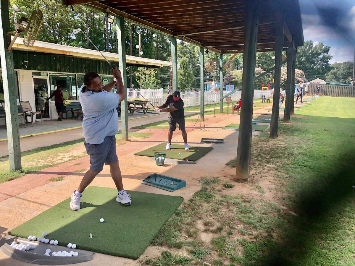 Cedric Smith, a member of 401 Par Golf, hits a ball on the driving range at 401 Par Golf with his son-in-law, Shawn Lavigne, on Wednesday, August 17, 2022.