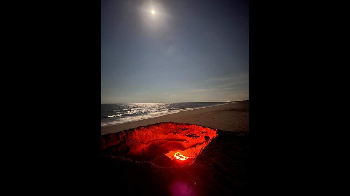 This hole found unattended on an Oak Island beach was 10 feet wide, and 4 feet deep and had a fire at the bottom of it, according to the Oak Island Fire Department.