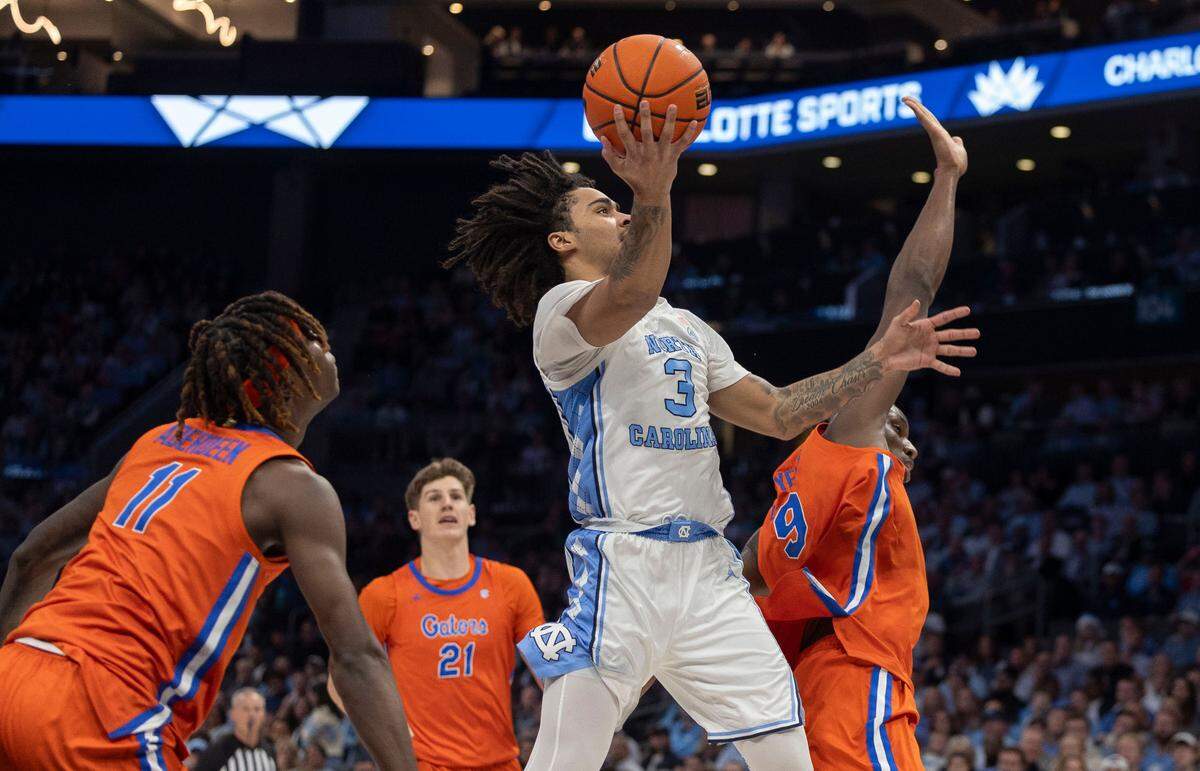 North Carolina guard Elliot Cadeau (3) drives to the basket against Florida’s Reuben Chinyelu (9) in the first half during the Jumpman Invitational on Tuesday, December 17, 2024 at the Spectrum Center in Charlotte, N.C.
