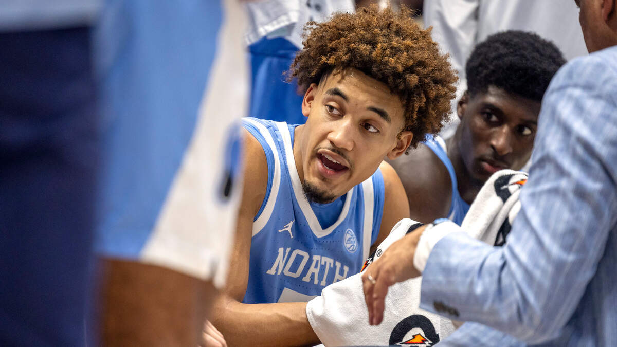 North Carolina guard Seth Trimble (7) talks with his teammates during a time-out huddle with coach Hubert Davis  in the second half against Duke on Saturday, February 1, 2025 at Cameron Indoor Stadium in Durham, N.C.