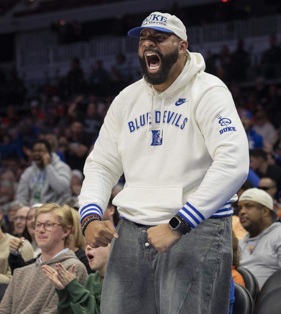 Carlos Boozer, the father of Duke players Cayden Boozer (2) and Cameron Boozer (12) cheers on his sons, after Cayden drew a foul and made a basket in the first half against Clemson on Friday, March 13, 2026, during the semifinals of the ACC Tournament at Spectrum Center in Charlotte,  N.C.