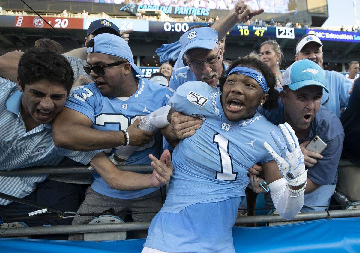 North Carolina’s Khafre Brown (1) jumps into the stands to celebrate the Tar Heels’ 24-20 victory over South Carolina with fans on Saturday, August 31, 2019 at Bank of America Stadium in Charlotte, N.C.