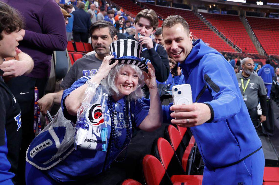 Duke head coach Jon Scheyer takes a selfie with Shelly Hudson-Baker of Raleigh after Duke’s open practice at the Lenovo Center in Raleigh, N.C., Thursday, March 20, 2025. The Blue Devils will face Mount St. Mary’s in the first round of the NCAA Tournament Friday.