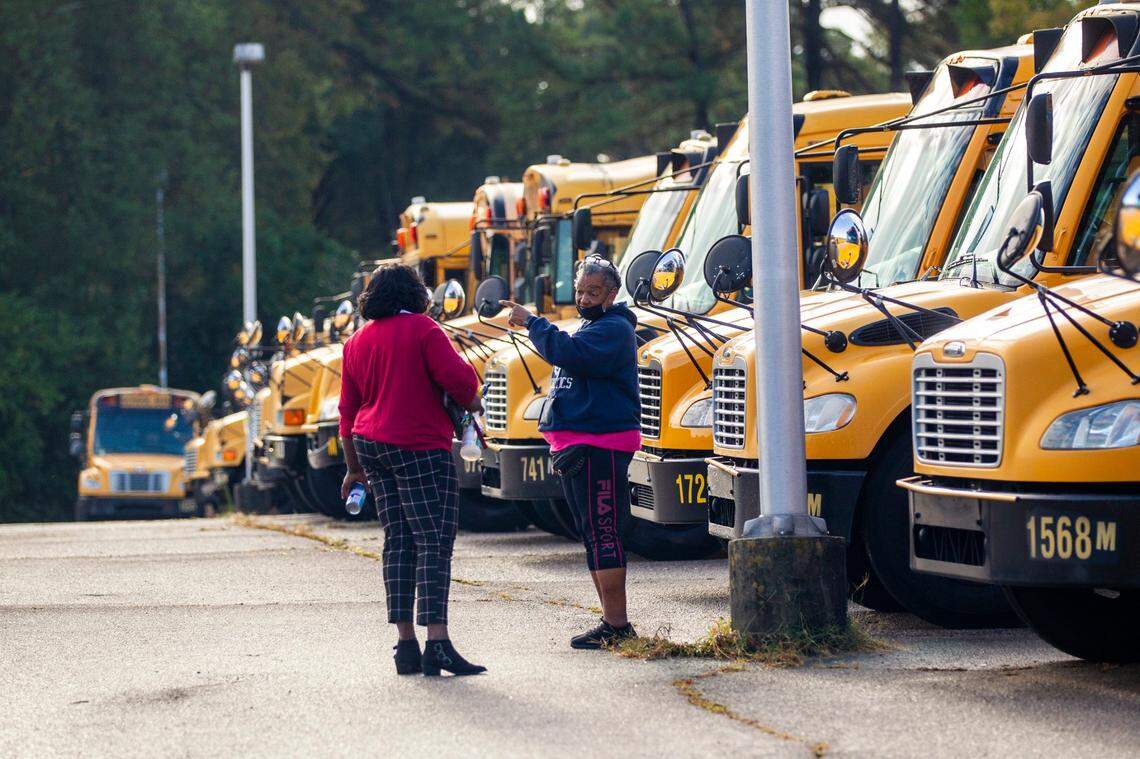 Wake County school bus drivers return to a parking area on Capital Blvd. in Raleigh after completing morning routes Friday, Oct. 29, 2021.
