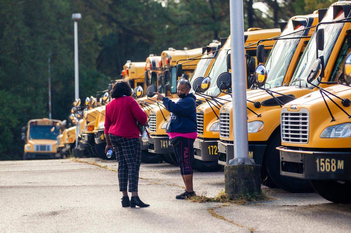 Wake County school bus drivers return to a parking area on Capital Blvd. in Raleigh after completing morning routes Friday, Oct. 29, 2021. Wake County parents and students experienced bus delays in 2021, and school officials warned of widespread delays as drivers began an expected sickout then.