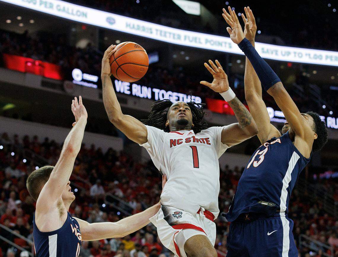 N.C. State’s Jayden Taylor drives to the basket past Virginia’s Isaac McKneely and Ryan Dunn during the second half of the Wolfpack’s 76-60 win on Saturday, Jan. 6, 2024, at PNC Arena in Raleigh, N.C.
