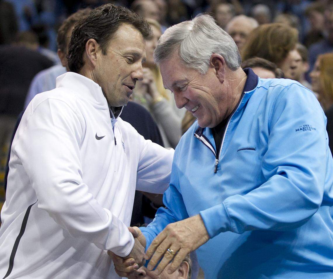 UNC football coach Larry Fedora (left) greets former UNC and Texas football coach Mack Brown prior to the Tar Heels’ basketball game against Florida State on Saturday, January 24, 2015 at the Smith Center in Chapel Hill, N.C.  Brown coached at North Carolina from 1988-1997.  