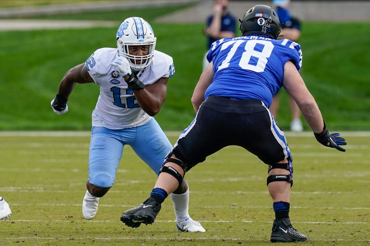 North Carolina Tar Heels linebacker Tomon Fox (12) runs around Duke Blue Devils offensive tackle Casey Holman (78) during the second half at Wallace Wade Stadium. 