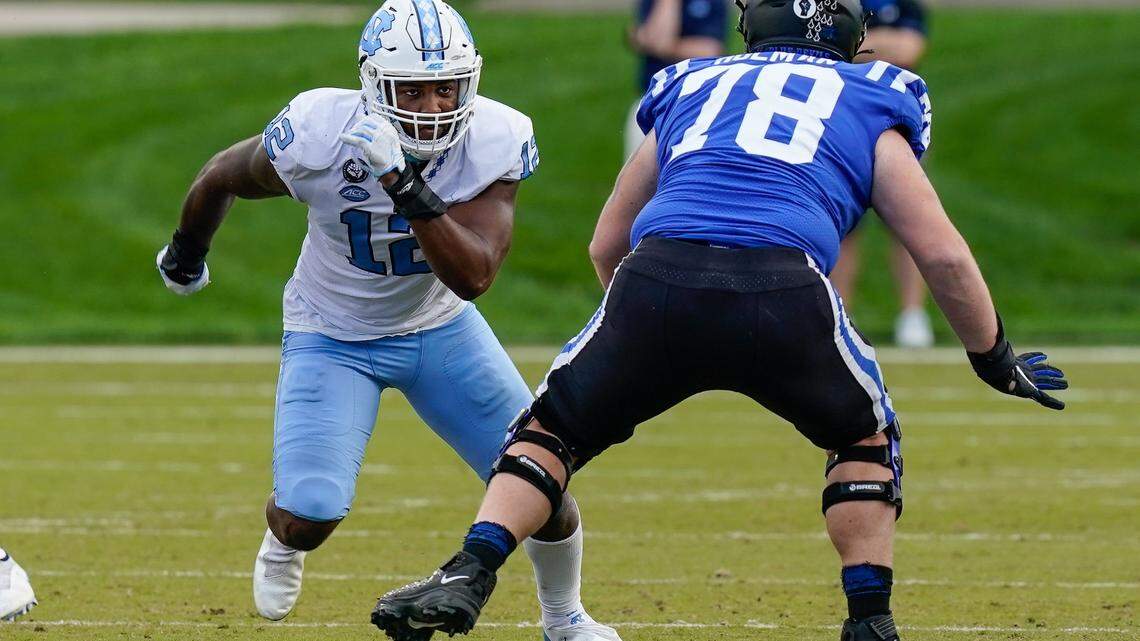 North Carolina Tar Heels linebacker Tomon Fox (12) runs around Duke Blue Devils offensive tackle Casey Holman (78) during the second half at Wallace Wade Stadium.
