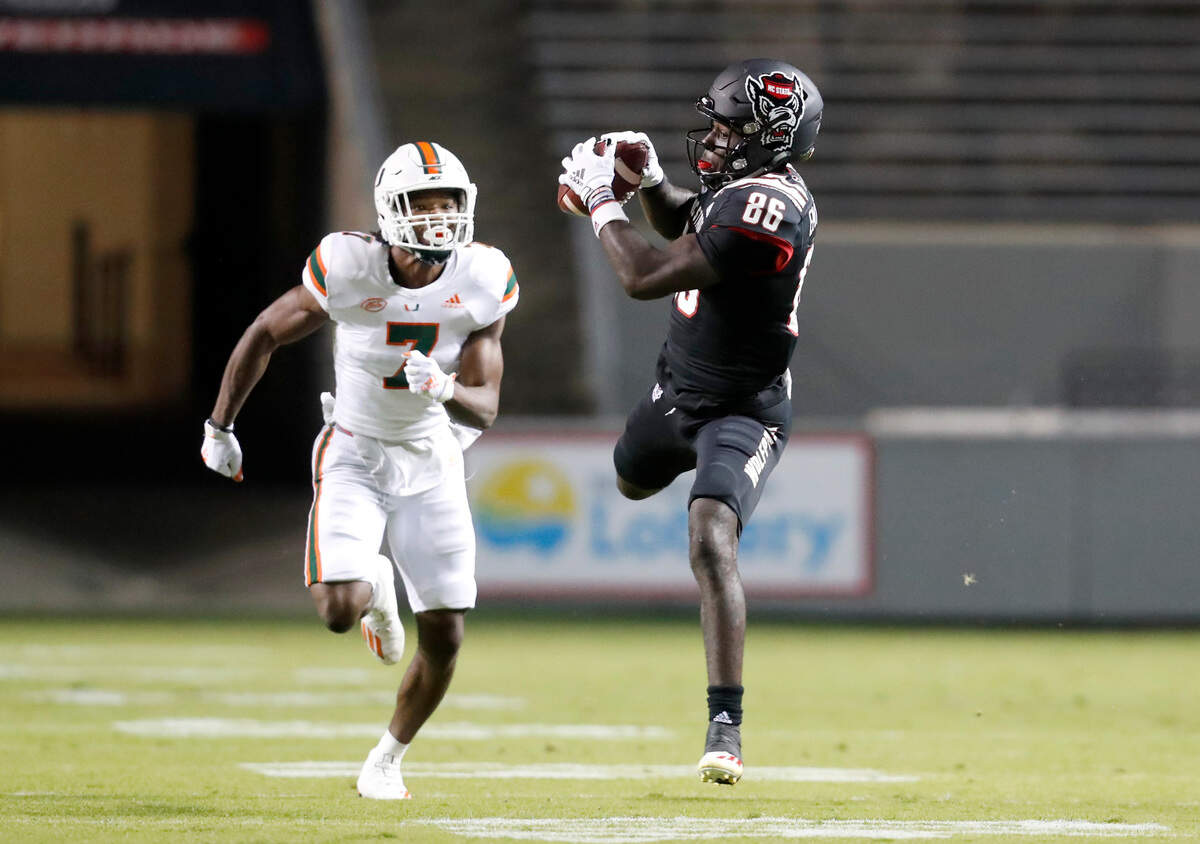 N.C. State wide receiver Emeka Emezie (86) pulls in a reception in front of Miami cornerback Al Blades Jr. (7) during the first half of N.C. State’s game against Miami at Carter-Finley Stadium in Raleigh, N.C., Friday, Nov. 6, 2020.