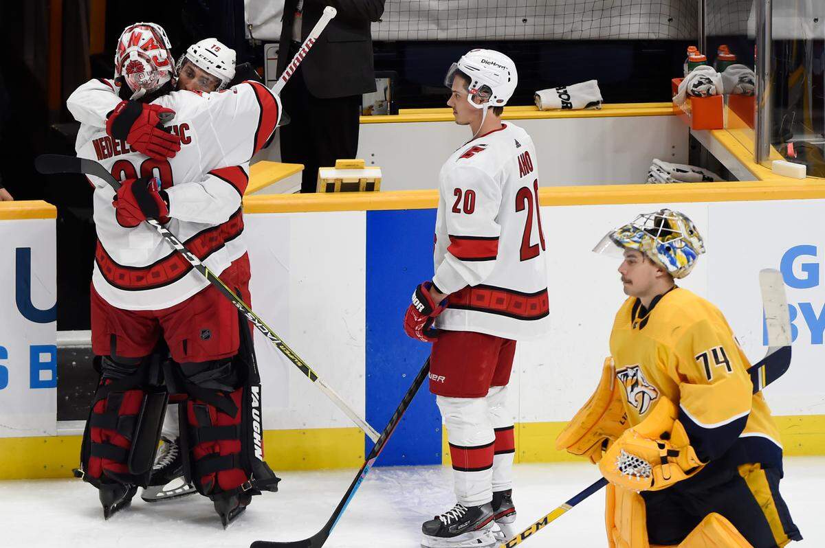 Carolina Hurricanes center Vincent Trocheck (16) hugs goaltender Alex Nedeljkovic (39) after beating the Nashville Predators in overtime of Game 6 of an NHL hockey Stanley Cup first-round playoff series Thursday, May 27, 2021, in Nashville, Tenn. Nashville Predators goaltender Juuse Saros (74) skates off the ice.