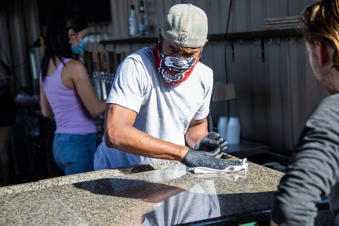 Bartender Bert Selby sanitizes a bar top Friday, May 22, 2020 at Lynnwood Brewing ConcernÕs Grove Barton Road location. North Carolina entered Phase Two of its reopening plan Friday, allowing restaurants and personal care services to open at 50% capacity.