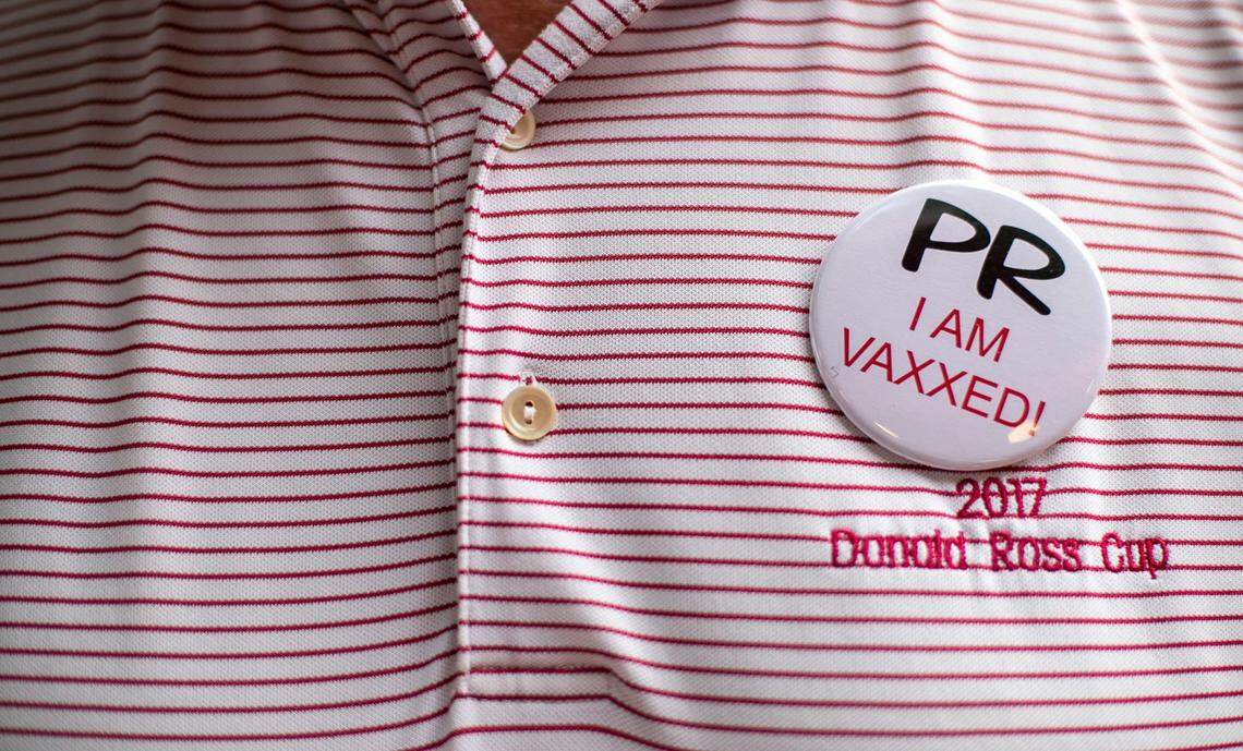 Players Retreat owner Gus Gusler wears one of the buttons that he will require customers to register for and wear to enter his business when it re-opens on June 23, 2021. Customers can register for their buttons beginning next week.