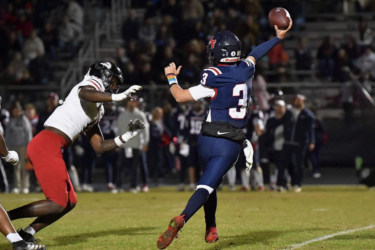 Rolesville's Zavion Griffin-Haynes pressures Apex Friendship quarterback Ethan McGarrigan (3) during the first half. The Apex Friendship Patriots and the Rolesville Rams met in  the second round of the  NCHSAA 8A Playoff game in Apex, N.C. on November 14, 2025. Rolesville wins 14-7 in overtime.