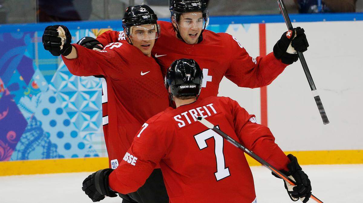 Switzerland forward Nino Niederreiter, left, Switzerland forward Simon Moser, right, and Switzerland defenseman Mark Streit (7) celebrate Switzerland’s 1-0 victory over Latvia during the 2014 Winter Olympics men’s ice hockey game at Shayba Arena, Wednesday, Feb. 12, 2014, in Sochi, Russia. (AP Photo/Petr David Josek)