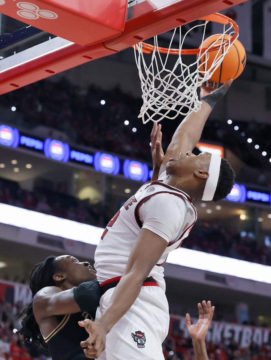 N.C. State’s Ven-Allen Lubin lays the ball in over Wake Forest’s Tre’Von Spillers during the second half of the Wolfpack’s 70-57 win on Wednesday, Dec. 31, 2025, at Lenovo Center in Raleigh, N.C.