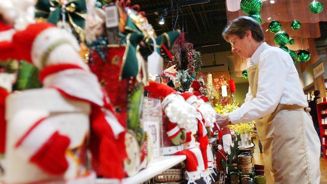 A sales associate straightens a Christmas gift basket display at a local shop in this News & Observer / Herald-Sun file photo.