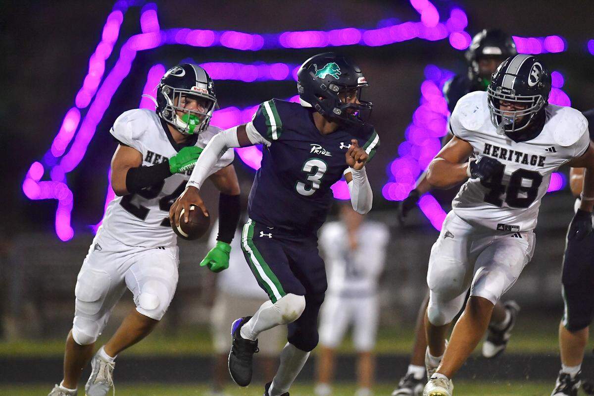Leesville Road quarterback Damacio Cueto (3) runs for yards against Heritage's Gabe Roberts (24) and Alexander Oliver (48) late in the first half.  The Leesville Road Pride and the Heritage Huskies met in a  football game in Raleigh, N.C. on September 5, 2025.