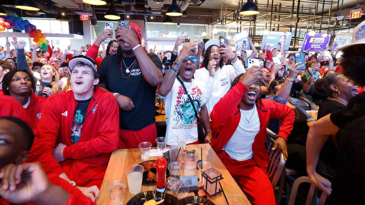 N.C. State players including from left, Ben Middlebrooks, DJ Burns Jr., DJ Horne, Jayden Taylor and Kam Woods along with coaches, staff and fans react as the Wolfpack are selected to play Texas Tech in the NCAA Tournament. The group gathered at Sports & Social in Cary, N.C., Sunday, March 17, 2024, to watch the selection show.