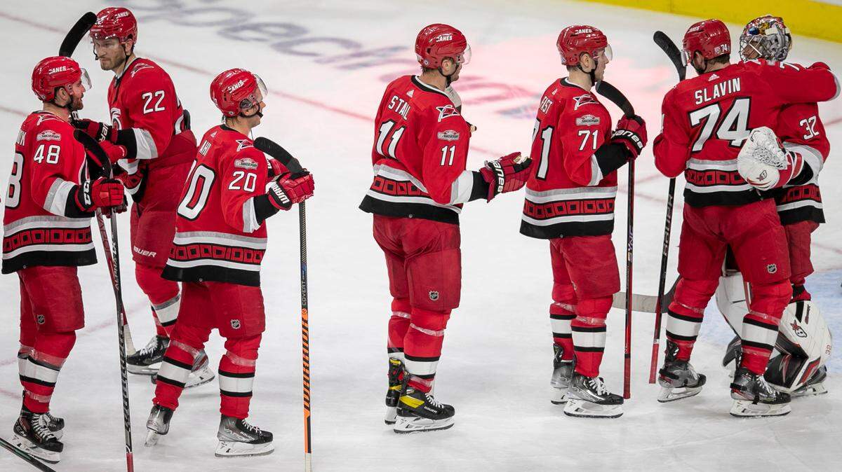 Carolina Hurricanes’ Jaccob Slavin (74) embraces goalie Antii Raanta (32) as they celebrate their 4-1 victory over Detroit on Tuesday, April 11, 2023 at PNC Arena in Raleigh, N.C. Raanta made 20 saves in the victory.