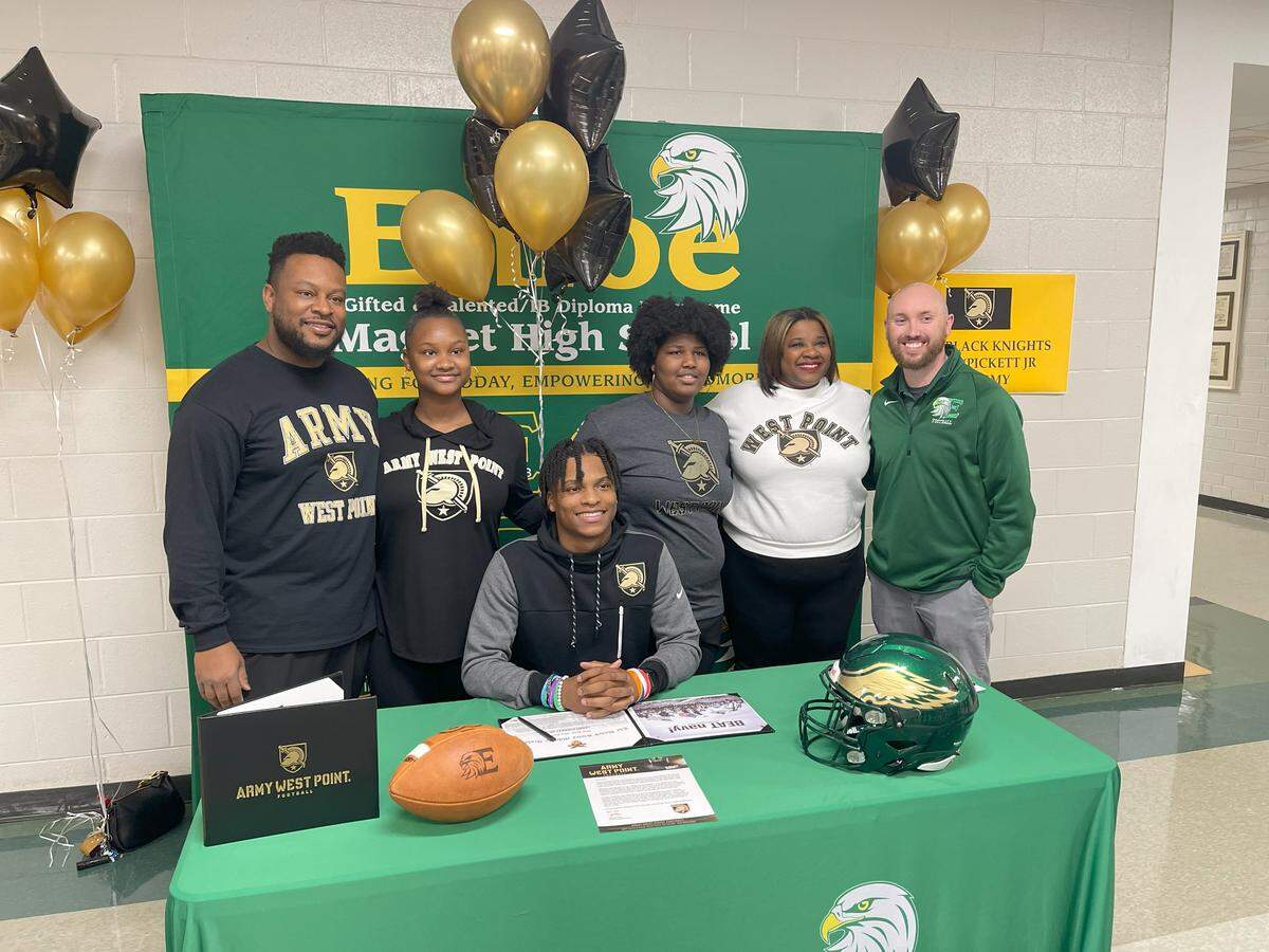 Larry Pickett Jr., seated, signs his letter of intent to play football for Army-West Point. Pictured with him at Enloe High School in Raleigh, N.C., are, from left to right: Larry Pickett Sr., Lauren Pickett, Shawnonne Pickett, Olivia Pickett, head football coach Ryan Clark.