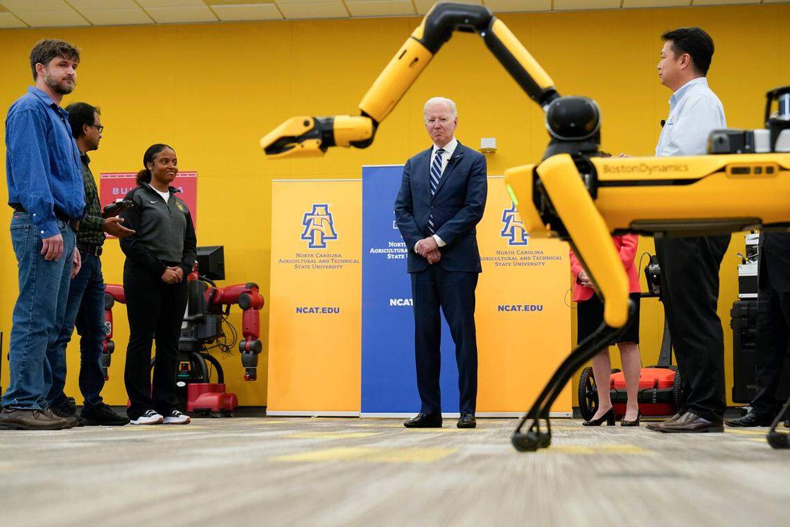 President Joe Biden looks at Spot, a Boston Dynamics robotic dog, during a tour at North Carolina Agricultural and Technical State University, in Greensboro, N.C., Thursday, April 14, 2022.