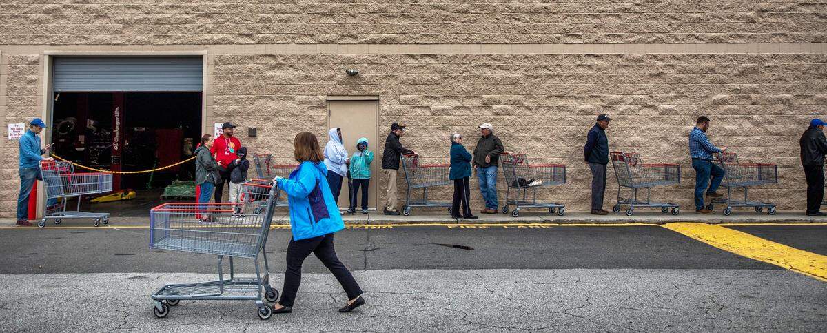 Shoppers line up outside Costco at 9:45am awaiting the 10am opening, where employees distributed one package of toilet paper per customer, on Tuesday, Mar. 17, 2020, in Durham, N.C.