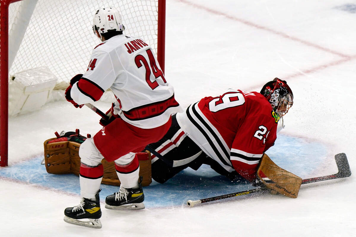 Carolina Hurricanes center Seth Jarvis, left, scores against Chicago Blackhawks goaltender Marc-Andre Fleury during the second period of an NHL hockey game in Chicago, Wednesday, Nov. 3, 2021. (AP Photo/Nam Y. Huh)