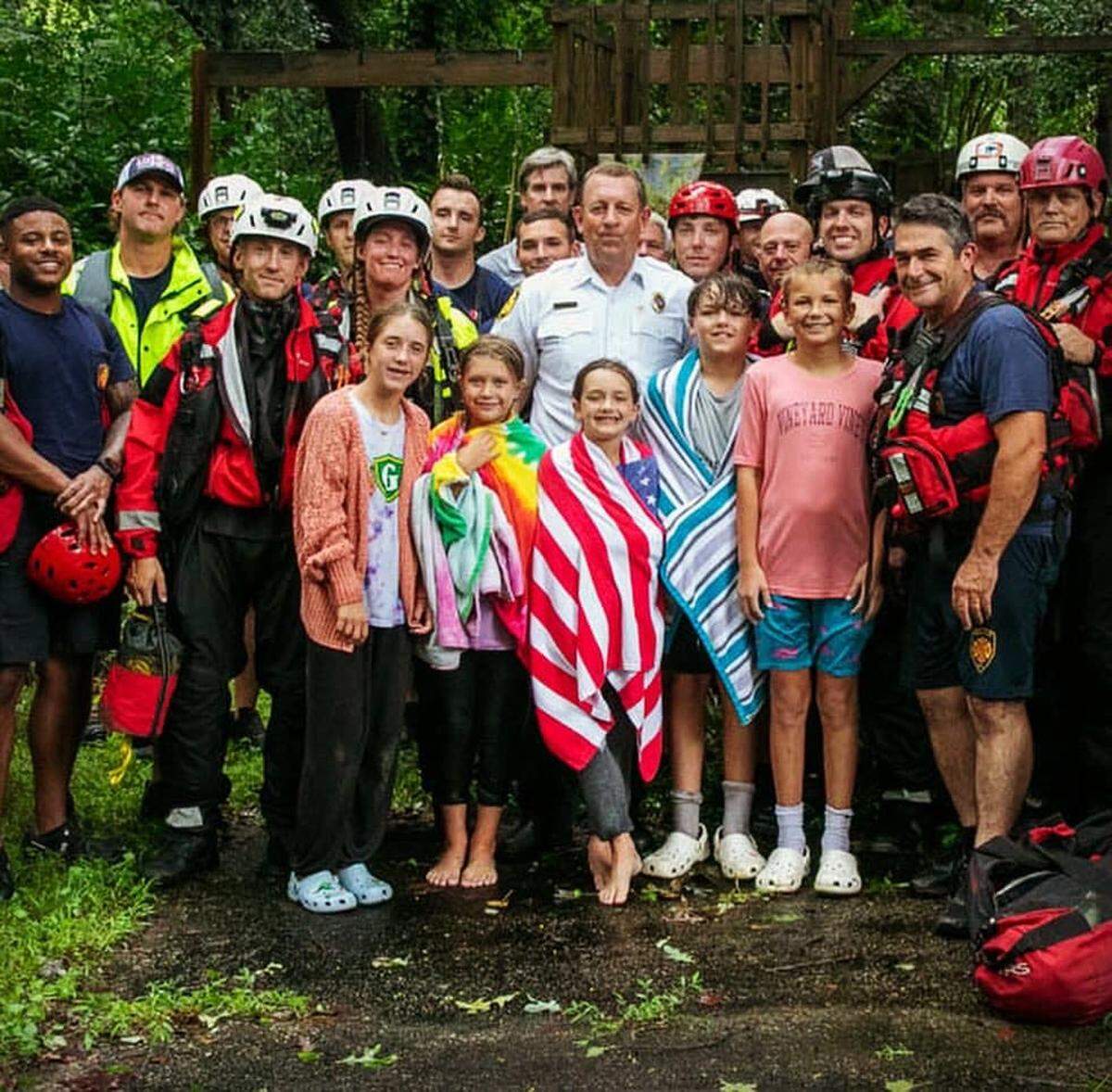 Raleigh emergency crews pose with children rescued from Marsh Creek in Raleigh on Thursday.