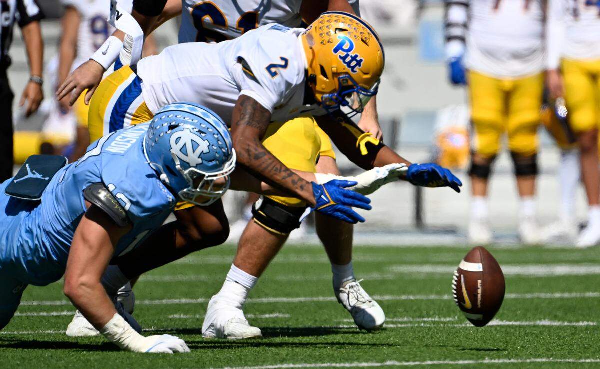 Pittsburgh Panthers wide receiver Kenny Johnson (2) and North Carolina Tar Heels defensive lineman Beau Atkinson (12) fight for a fumble in the first quarter at Kenan Memorial Stadium.