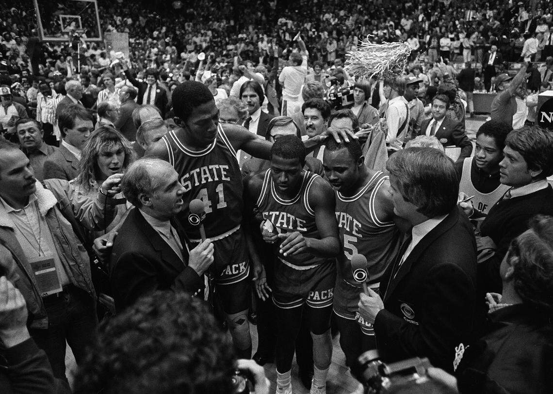 CBS announcer Billy Packer, left, interviews N.C. State seniors Thurl Bailey, Dereck Whittenburg, and Sidney Lowe after the Wolfpack won the National Championship on April 4, 1983. The Wolfpack won the game 54-52.