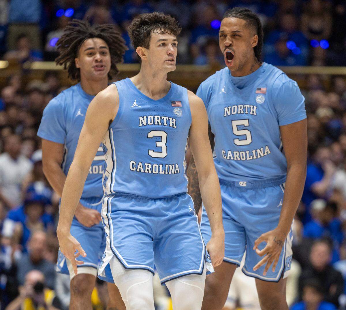 North Carolina’s Cormac Ryan (3), Armando Bacot (5), and Elliot Cadeau (2) react after Ryan hit his third three-point basket in the first half to give the Tar Heels’ a 15-4 lead over Duke on Saturday, March 9, 2024 at Cameron Indoor Stadium in Durham, N.C.