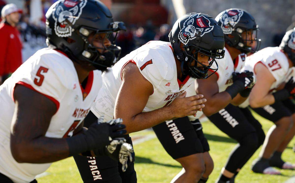 From left, N.C. State’s C.J. Clark (5), Davin Vann (1) and Savion Jackson (9) warm up before N.C. State’s game against Virginia Tech at Lane Stadium in Blacksburg, VA, Saturday, Nov. 18, 2023.
