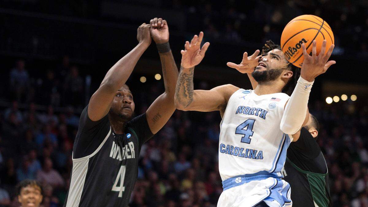 North Carolina’s R.J. Davis (4) drives to the basket against Wagner’s Tyje Kelton (4) in the first half on Thursday, March 21, 2024 during the NCAA Tournament at Spectrum Center in Charlotte, N.C.
