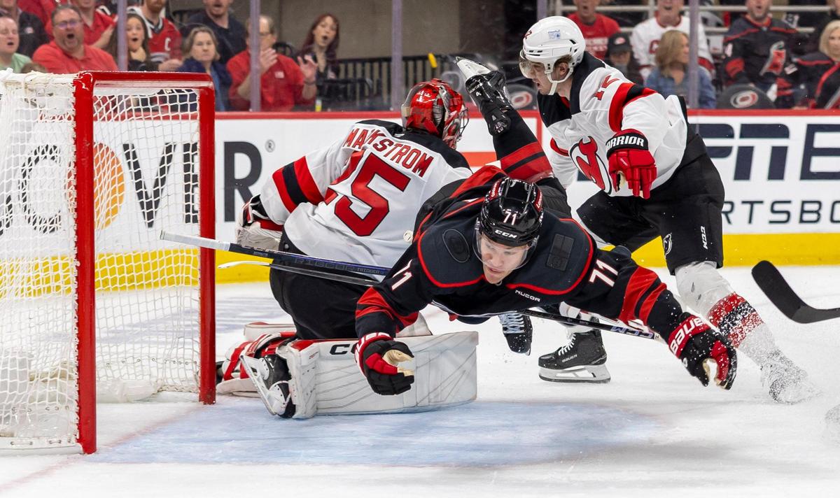 Carolina Hurricane left wing Taylor Hall (71) goes airborne as he chases down the puck in front of New Jersey goalie Jacob Markstrom (25) in the first period on Sunday, April 20, 2025 at Lenovo Center in Raleigh, N.C.