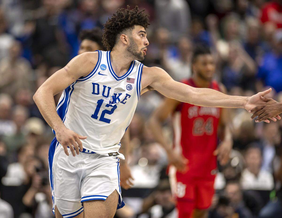 Duke forward Cameron Boozer (12) reaches for the hand of teammate Isaiah Evans (3) in the final seconds of play against St. John’s on Friday, March 27, 2026, during the Sweet Sixteen of the NCAA Tournament at Capital One Arena in Washington, D.C.