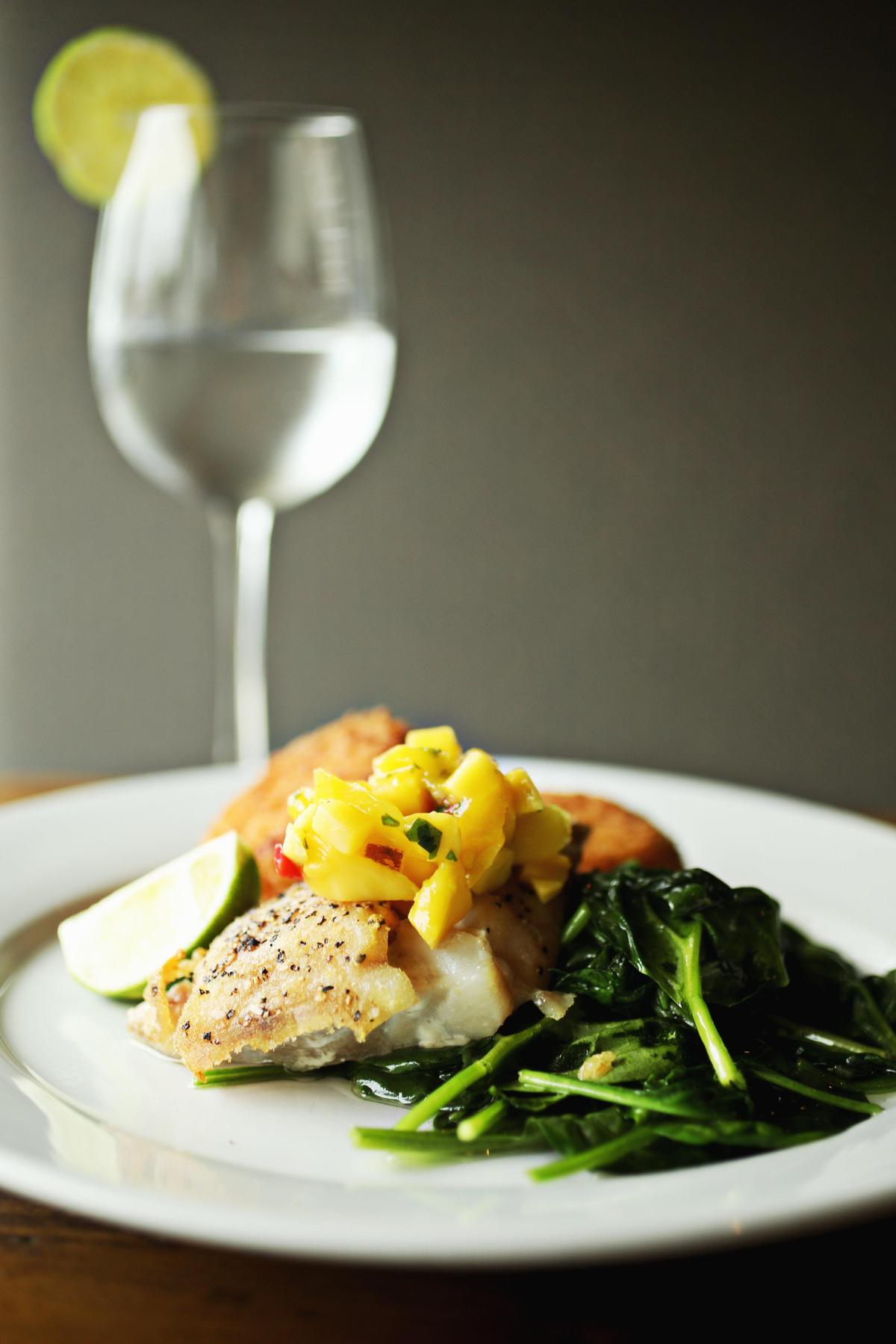 Cape Fear Seafood Company’s fresh catch is selected daily for quality - it is served here with mango salsa and two sides.