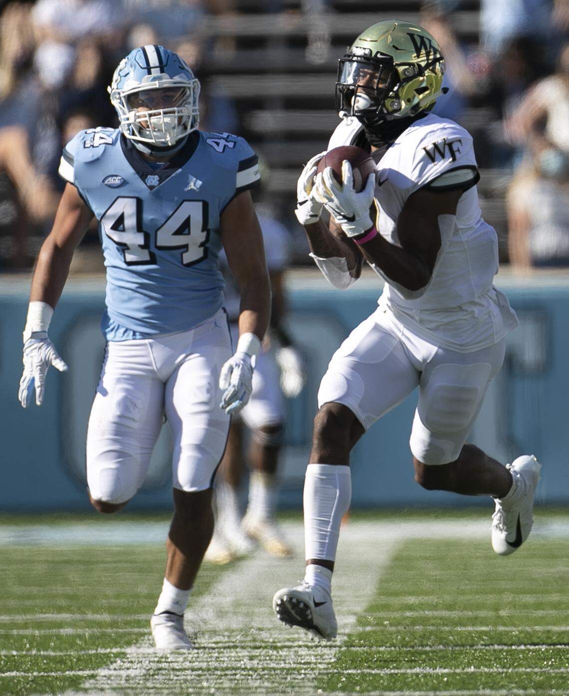 Wake Forest receiver Donavon Greene (7) pulls in a 39-yard pass quarterback Sam Hartman (10) ahead of North Carolina’s Jeremiah Gimmel (44) in the second quarter at Kenan Stadium on Saturday, November 14, 2020 in Chapel Hill, N.C.